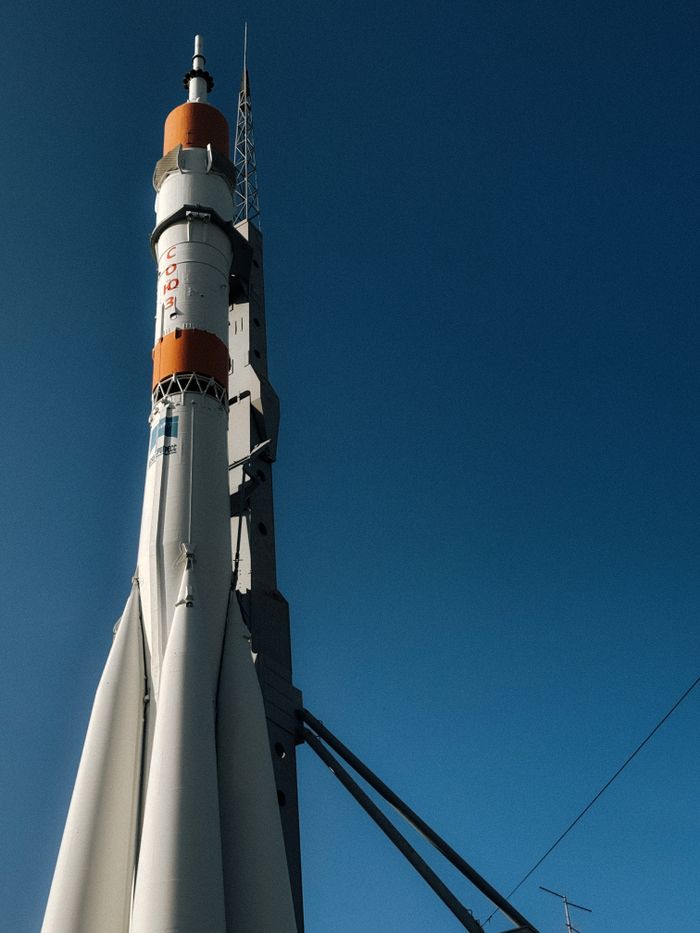 A rocket stands tall against a clear blue sky, symbolizing exploration.